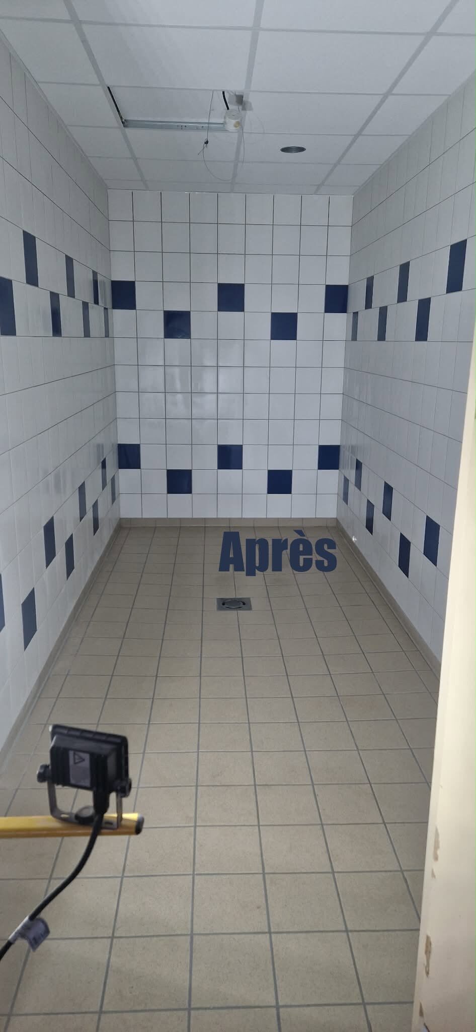 Après : couloir carrelé de blanc avec bande de carreaux bleus