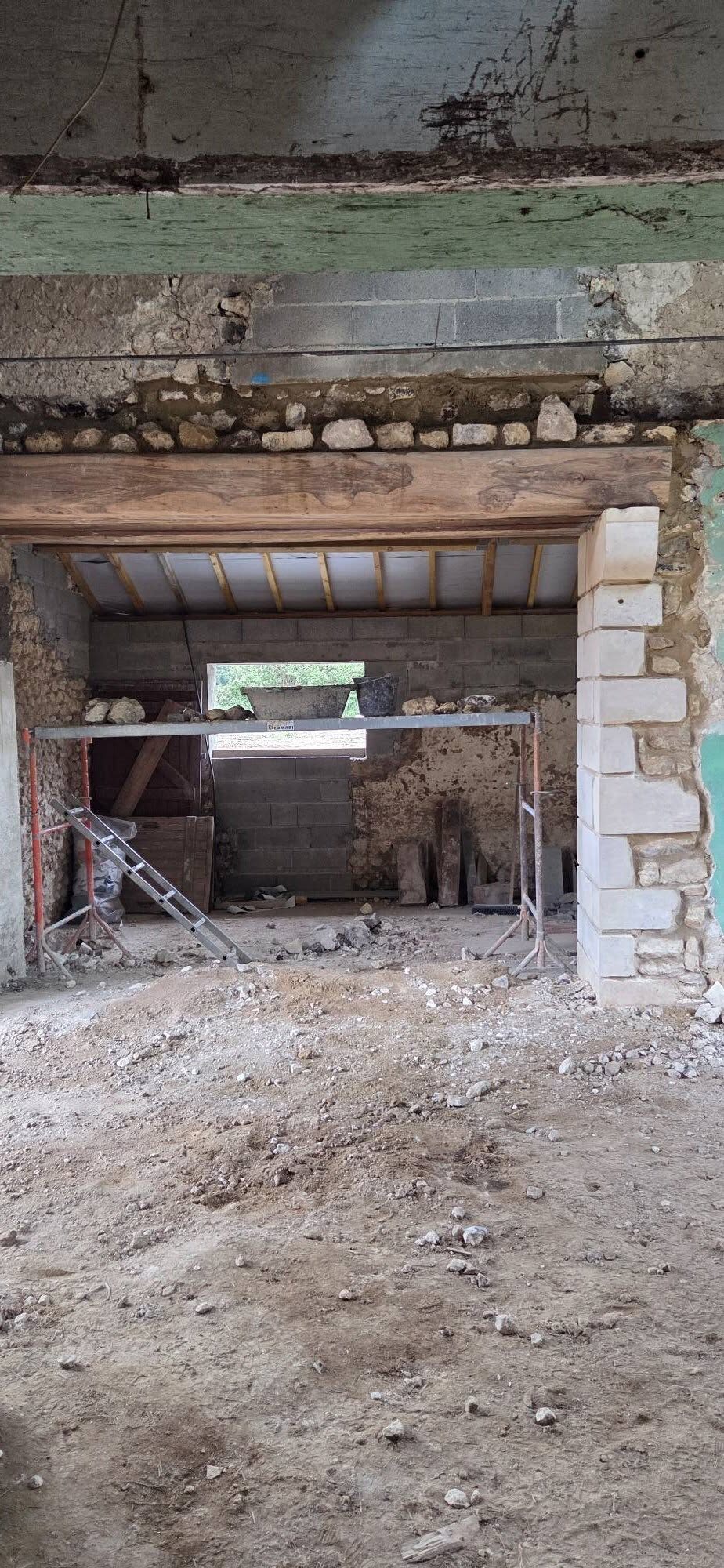Ouverture dans un mur de grange avec linteau en bois et jambage en pierre