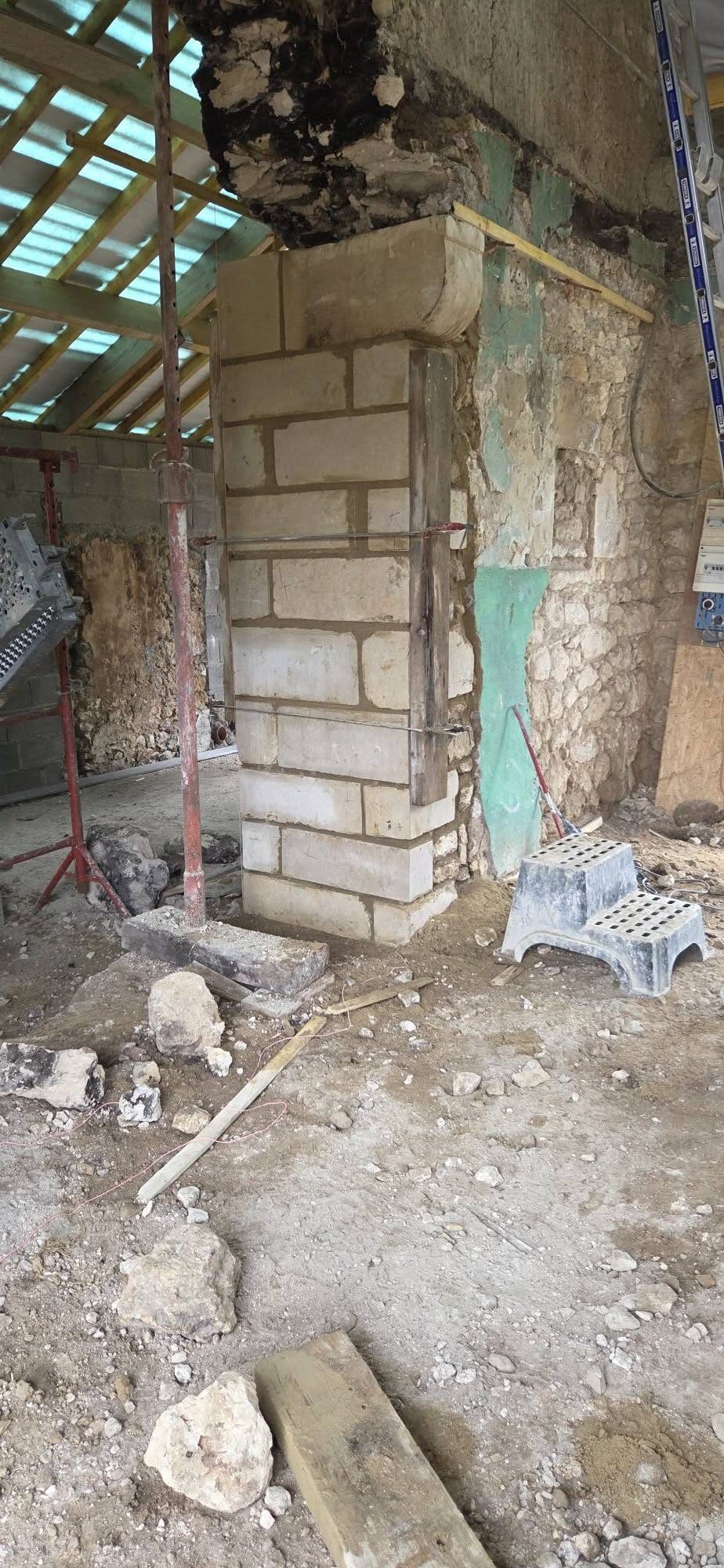 Pilier en pierre de taille monté dans une grange en rénovation