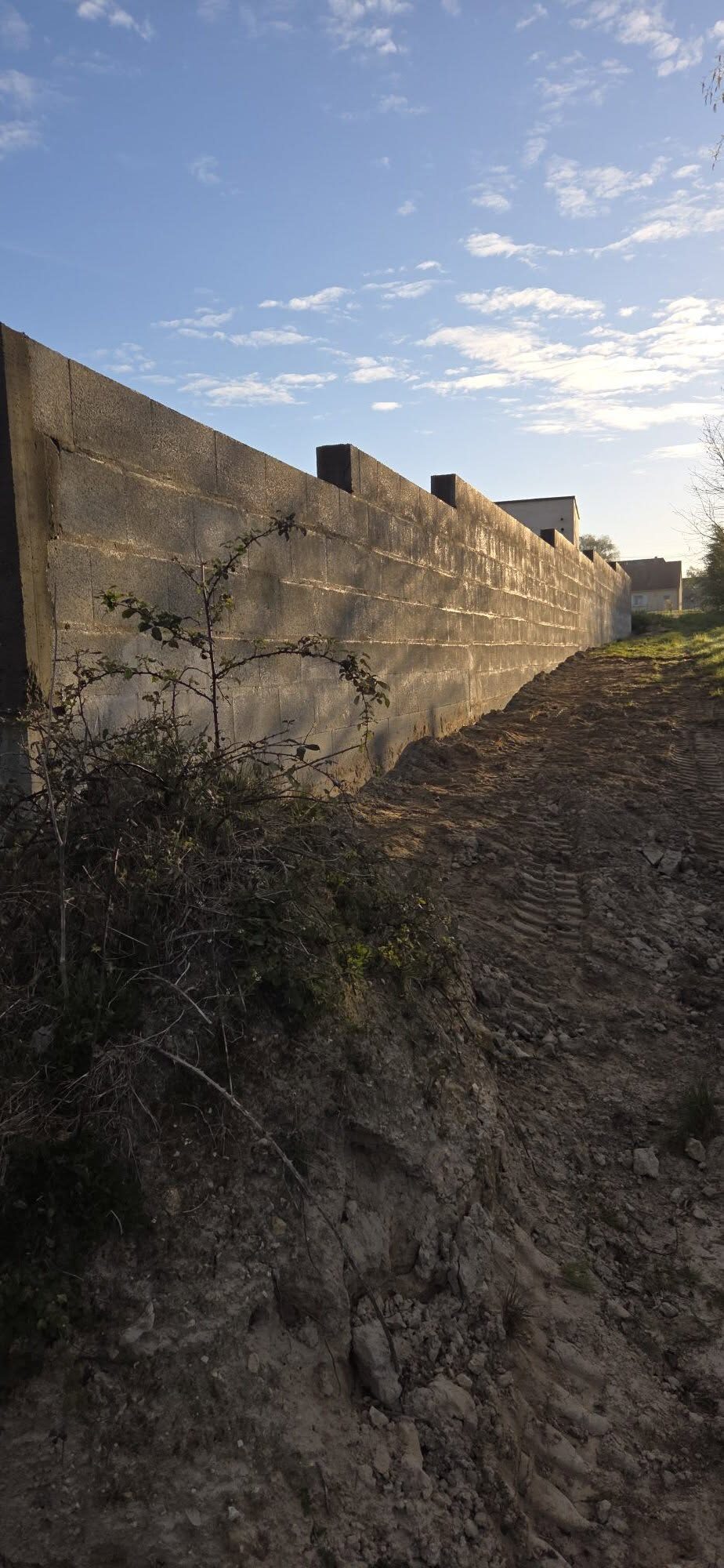 Mur de clôture en parpaings en cours de montage