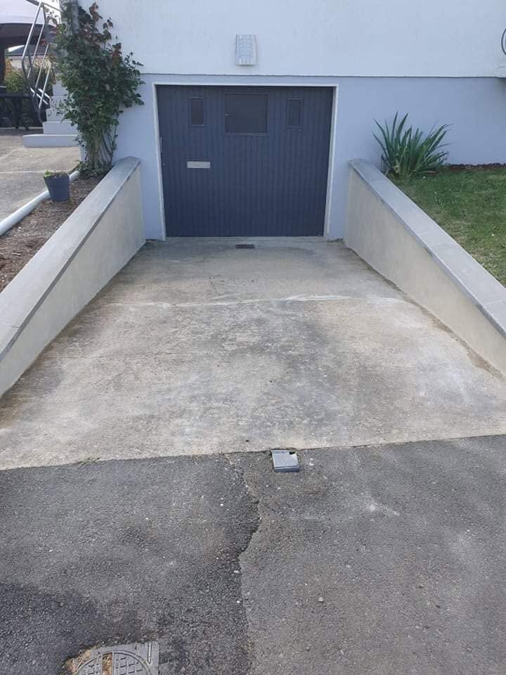 Murets de soutènement en béton de part et d'autre d'une rampe de garage