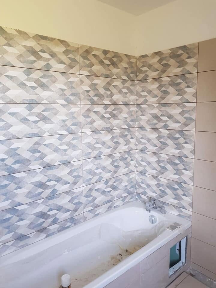 Baignoire encadrée de faïence à motifs géométriques bleus et gris
