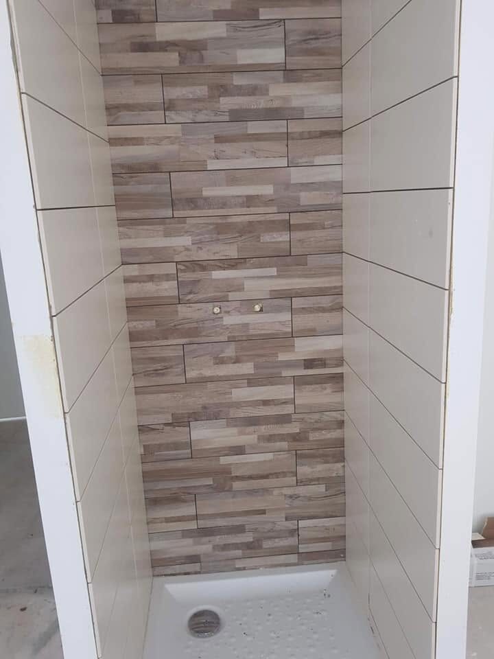 Douche à l'italienne carrelée, bande de faïence aspect bois et receveur blanc