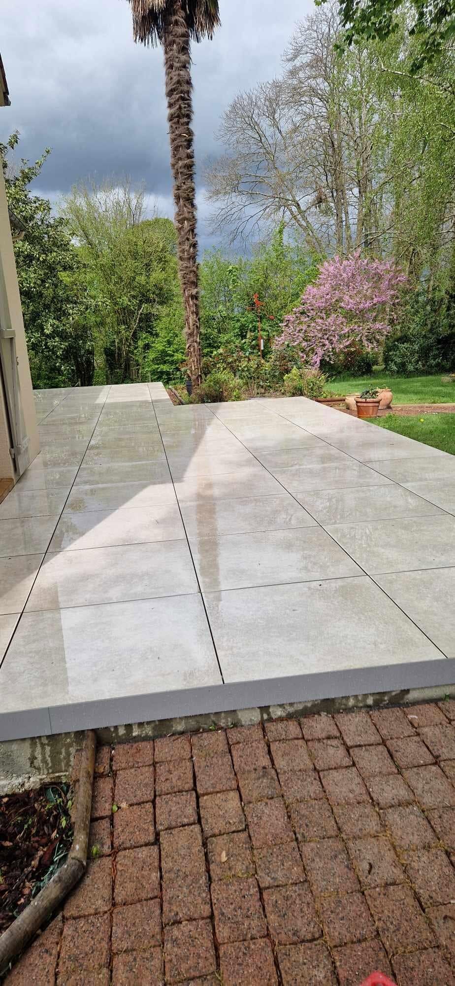 Terrasse en dalles claires grand format, bord net au-dessus du jardin